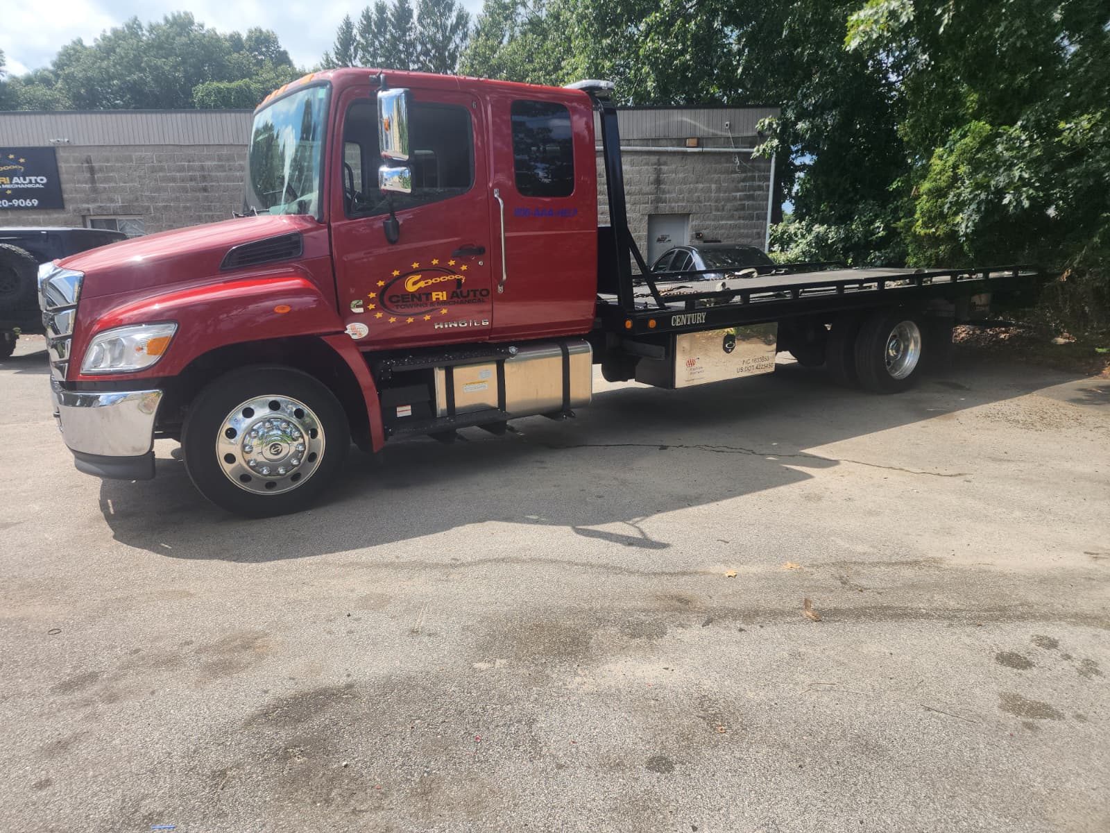 Centri Auto Towing flatbed truck parked at the shop