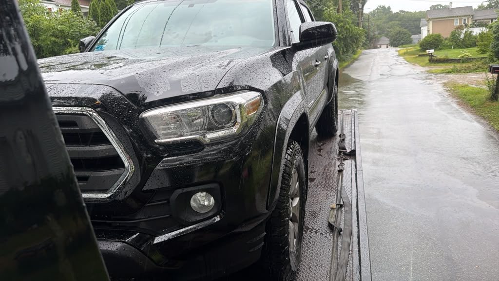 Pickup truck being towed in the rain