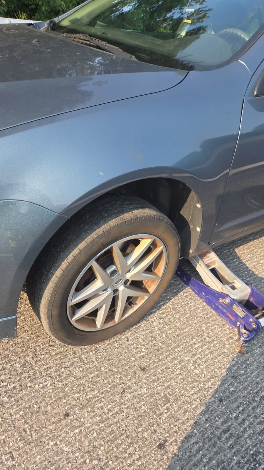 Roadside tire change on a sedan