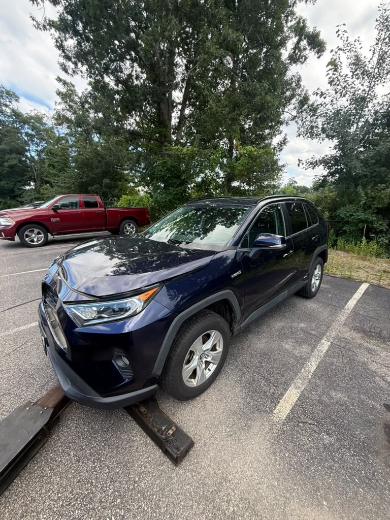 SUV loaded onto a Centri Auto flatbed tow truck in a parking lot