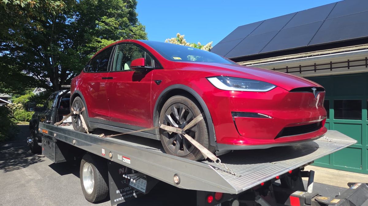 Red electric SUV loaded onto a Centri Auto flatbed tow truck