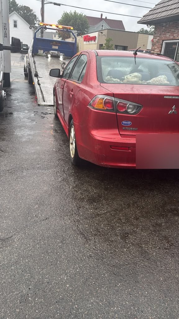Sedan loaded on a flatbed tow truck