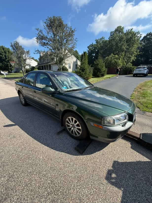 Green sedan being loaded from a driveway